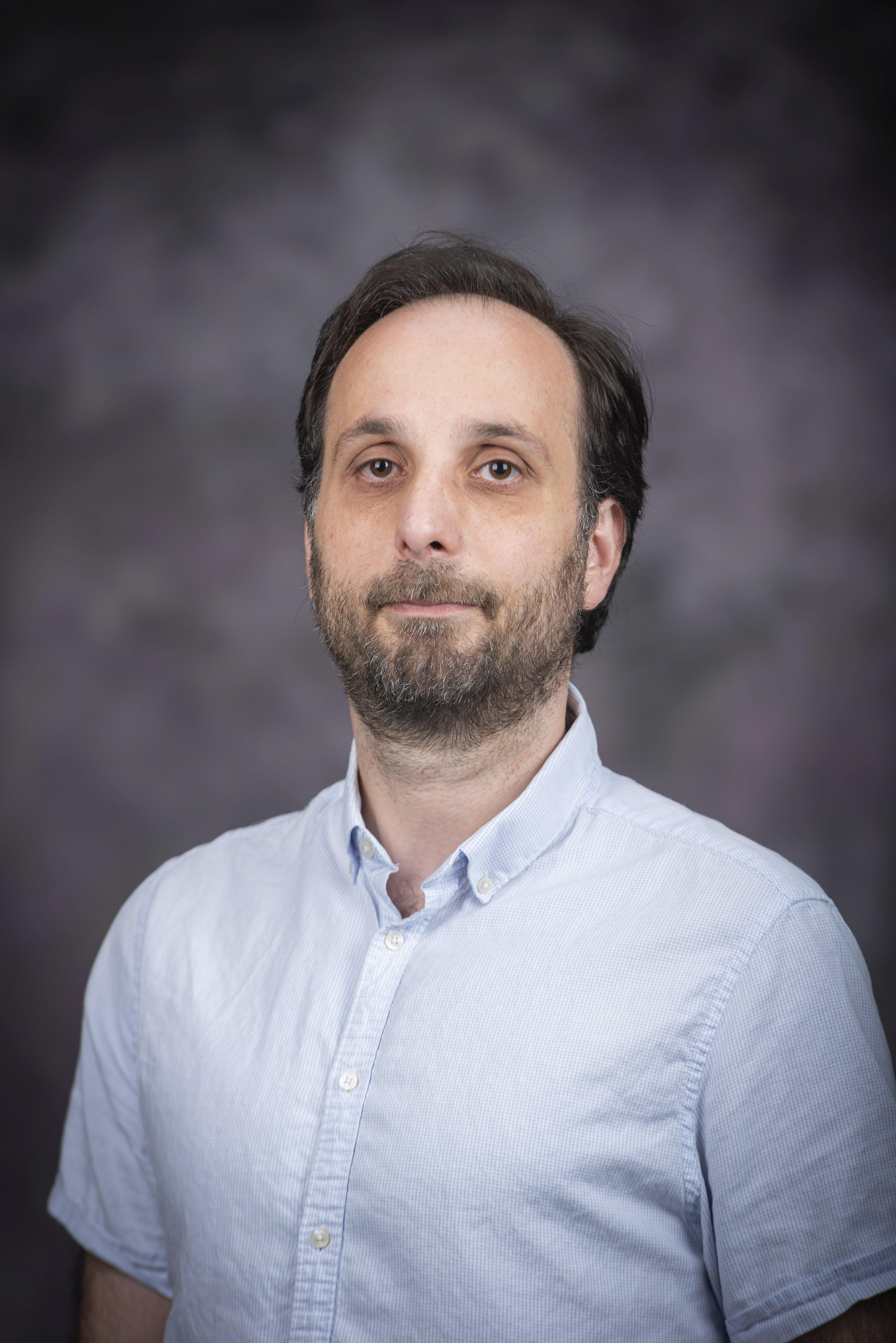 man with beard smiling in light blue shirt
