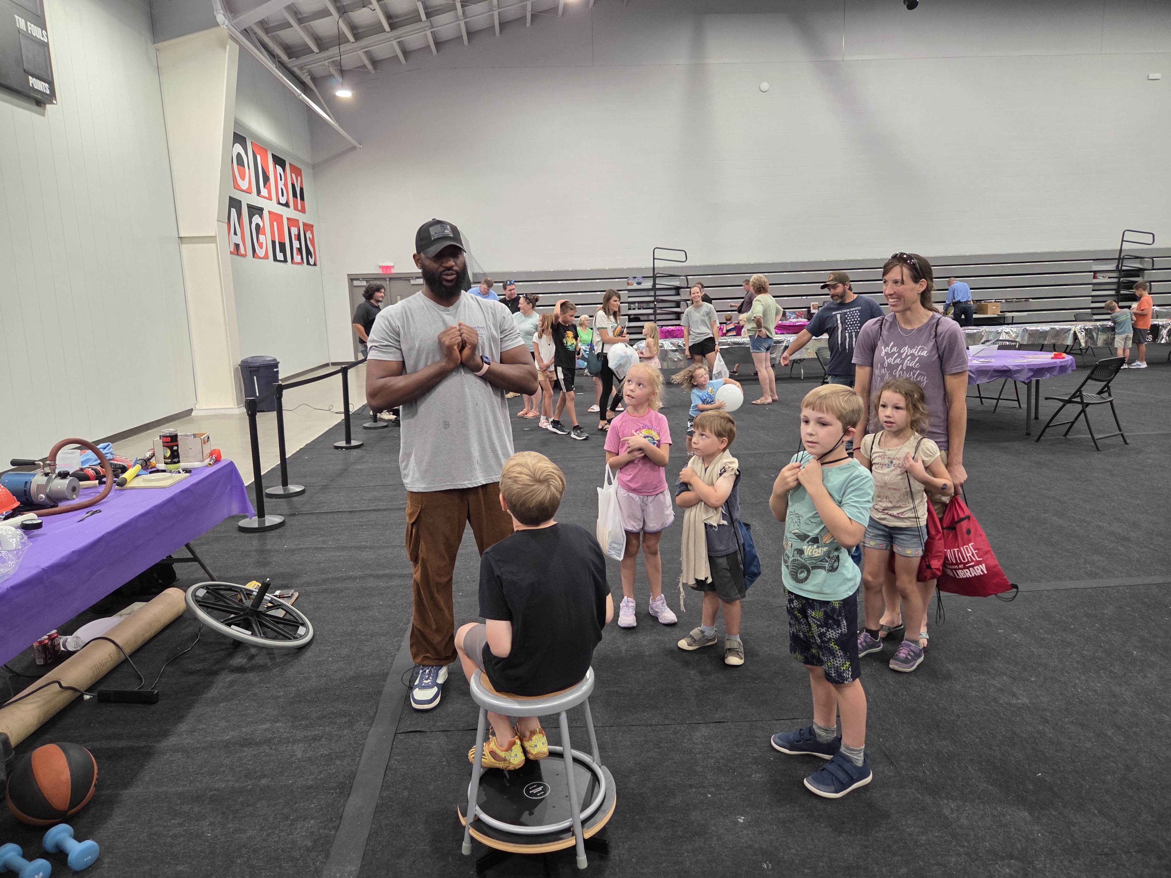 Physics graduate student Paul Onu presents a hands-on science demonstration to children at the Rocks and Rockets event in Colby, KS.